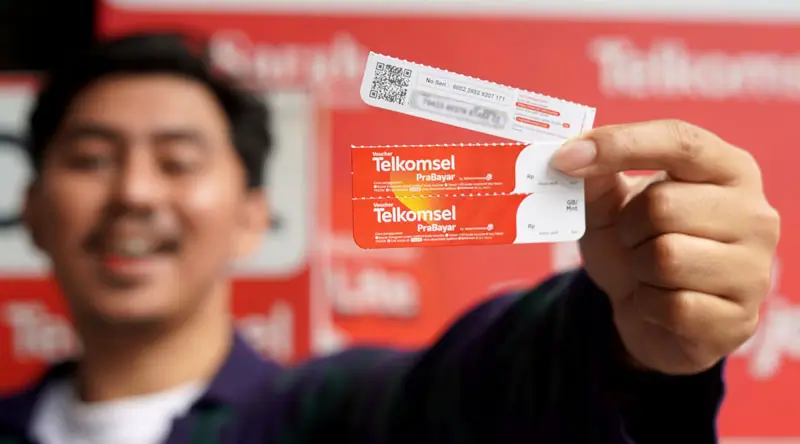 Pelanggan prabayar menunjukkan kartu prabayar Telkomsel dalam program undian berhadiah "Digosok Hepi". (Foto: Telkomsel)
