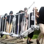 Relawan Trash Rangers Sulteng mengangkat Trash Boom untuk dipasang di depan pantai kawasan konservasi, pantai Dupa, Layana Indah, Minggu (26/1/2025). (Foto: Trash Rangers Sulteng)