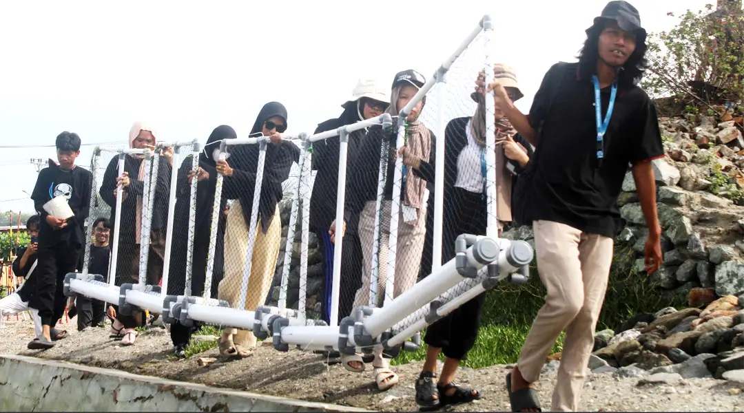Relawan Trash Rangers Sulteng mengangkat Trash Boom untuk dipasang di depan pantai kawasan konservasi, pantai Dupa, Layana Indah, Minggu (26/1/2025). (Foto: Trash Rangers Sulteng)
