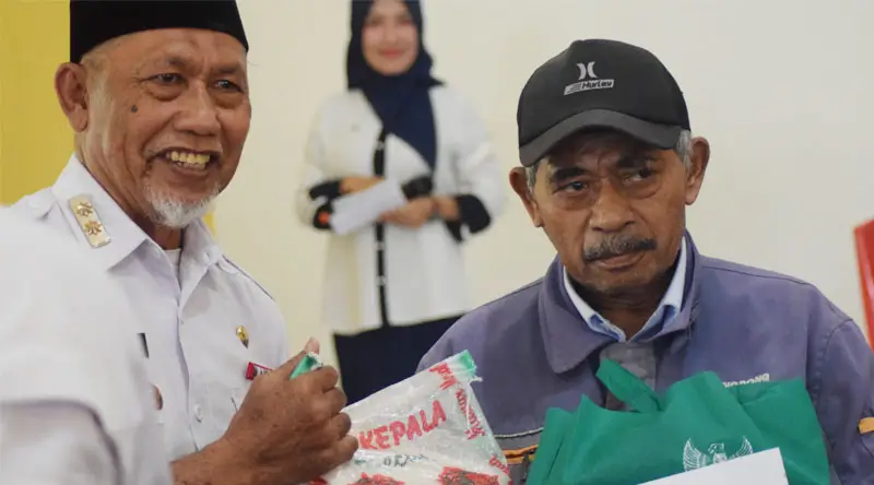 Asisten Kesra, Usman (kiri) menyerahkan bantuan sembako dan uang tunai dari Basnaz Kota Palu ke warga penerima manfaat di Kantor Camat Ulujadi, Rabu (19/2/2025). (Foto: Prokopim Setda Kota Palu/Imron)