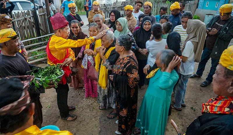 Pemuka adat memercikkan air pada permulaan ritual Pompaura di Poboya, Senin (24/2/2025). (Foto: beritapalu.com/bmz)
