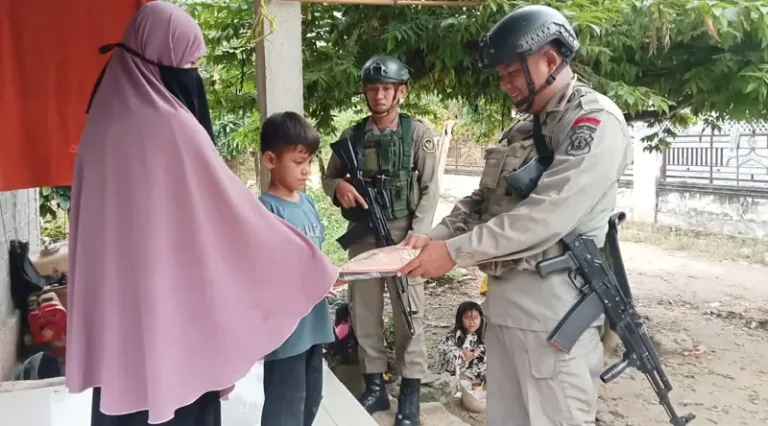 Personel Satagas Madago Raya menyerahkan seragam Merah Putih kepada seorag anak di wilayah Operasi, Poso, Minggu (9/2/2025). (Foto: HUmas Ops Madago Raya)