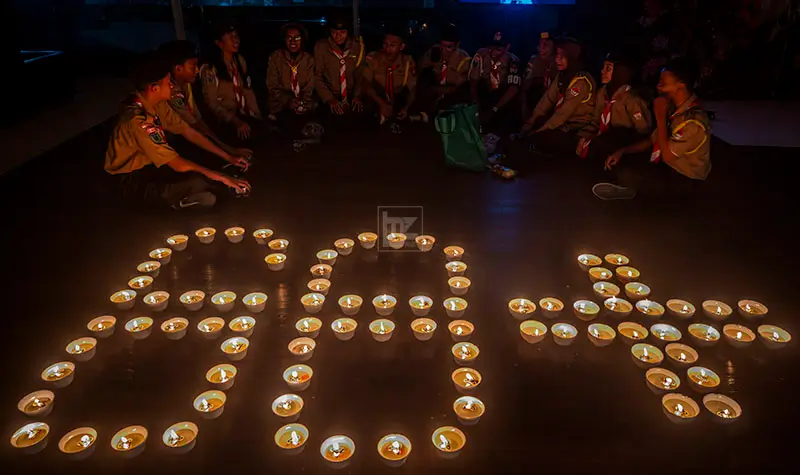 Sejumlah anggota Pramuka melakukan aksi teaterikal saat pemadaman lampu selama satu jam pada peringatan Earth Hour di Hotel Best Western Plus Coco, Palu, Sulawesi Tengah, Sabtu (22/3/2025) malam. (Foto: bmzIMAGES/Basri Marzuki)