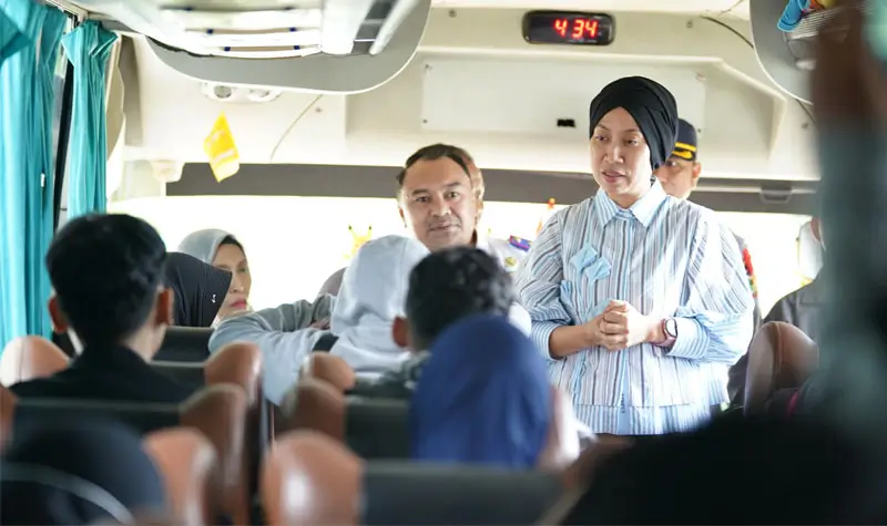 Wawali Imelda Lilianan Muhidin berbincang dengan warga peserta mudik gratis di atas bus saat tiba di Terminal Tipo, Palu, Minggu (23/1/2025). (Foto: Prokopim Setda Kota Palu/Jufri)