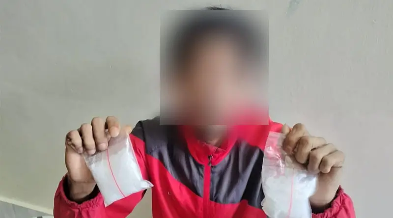 R, terduga kurir sabu menunjukkan dua paket sabu di Polda Sulteng, Selasa (11/3/2025). (Foto: Humas Polda Sulteng)