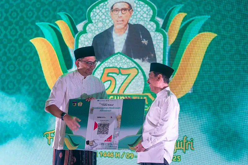 Kepala Perwakilan BI Sulteng, Rony Hartawan (kiri) menyerahkan kode QRIS untuk penggalangan dana wakaf tunai kepada Ketua Umum PB Alkhairaat Mohsen Alydrus pada pembukaan Festival Raudhah Haul Guru Tua ke-57 di Palu, Rabu (9/4/2025). (Foto: bmzIMAGES/Basri Marzuki)