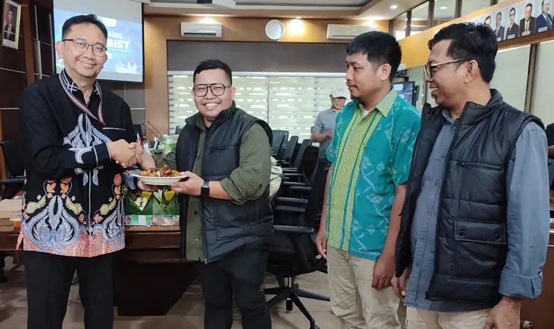 Kepala Perwakilan Bank Indonesia Sulawesi Tengah, Rony Hartawan (kiri) menyerahkan nasi tumpeng kepada Ketua Forjubist, Taufan usai pengukuhan di Kantor BI Sulteng, Palu, Senin (21/4/2025). (Foto: bmz)