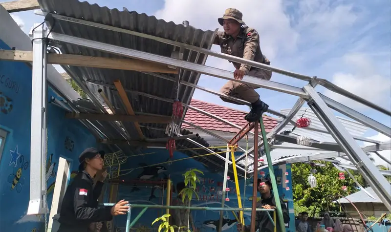Personel Satgas Madago Raya memperbaiki atap rumah warga korban puting beliung di Desa Tabalu, Pos, Senin (7/4/2025). (Foto: Humas Satgas Madago Raya)