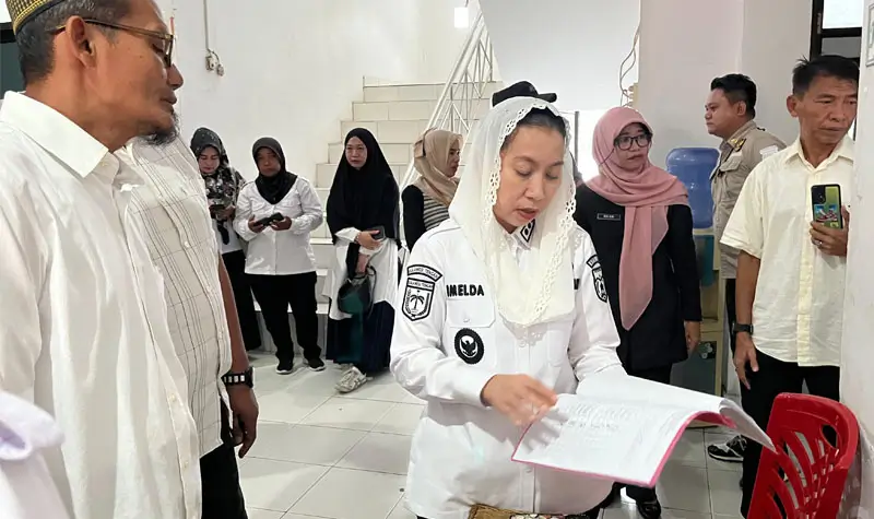 Wakil Wali Kota Palu, Imelda Liliana Muhidin mengecek daftar hadir pegawai saat melakukan sidak di salahs atu OPD di Pemkot Palu, Rabu (9/4/2025). (Foto: Prokopim Setda Kota Palu/Jufri)