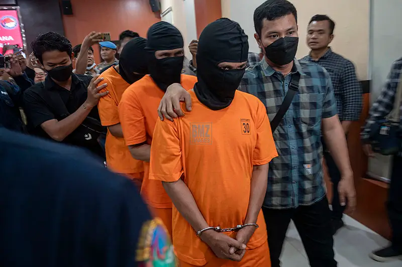Polisi berpakaian sipil mengawal tiga tersangka kasus narkotika jaringan internasional usai konferensi pers di Mapolda Sulteng, Palu, Sulawesi Tengah, Selasa (22/4/2025). (bmzIMAGES/Basri Marzuki)
