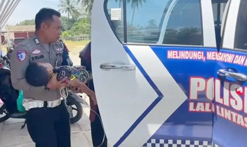 Aipda Wayan Wijaya memapah seorang anak yang kejang-kejang untuk dibawa ke RS Kolonodale di Morowali Utara, Selasa (8/4/2025). (Foto: Humas Polres Morowali Utaar)