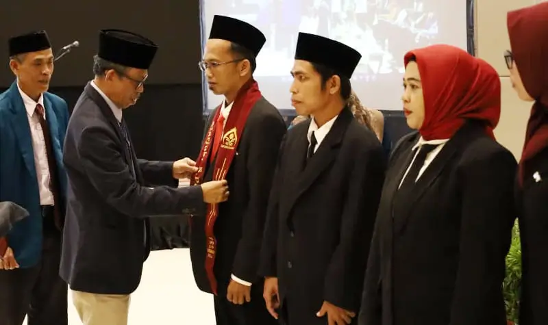 Rektor UNI Datokarama Palu, Prof Lukman Thahir menyematkan selempang kepada lulusan guru batch II di Palu, Selasa (15/4/2025). (Foto: UIN Datokarama)