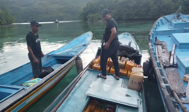 Petugas berada di perahu yang mengangkut solat bersubsidi yang akan dikirim ke Maluku Utara di Banggai Laut. (Foto: Dipolairu Polda Sulteng)