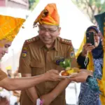 Wali Kota Hadianto Rasyid menyerahkan tumpeng kepada Ketua Tim Penggerak PKK Kota PAlu, Diah Puspita pada peringatan Harganas ke-32 di halaman Kantor wali Kota Palu, Senin (30/6/2025). (Foto: Prokopim Setda Kota Palu/Jufri)