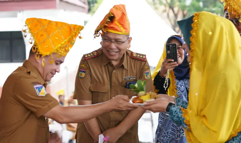 Wali Kota Hadianto Rasyid menyerahkan tumpeng kepada Ketua Tim Penggerak PKK Kota PAlu, Diah Puspita pada peringatan Harganas ke-32 di halaman Kantor wali Kota Palu, Senin (30/6/2025). (Foto: Prokopim Setda Kota Palu/Jufri)