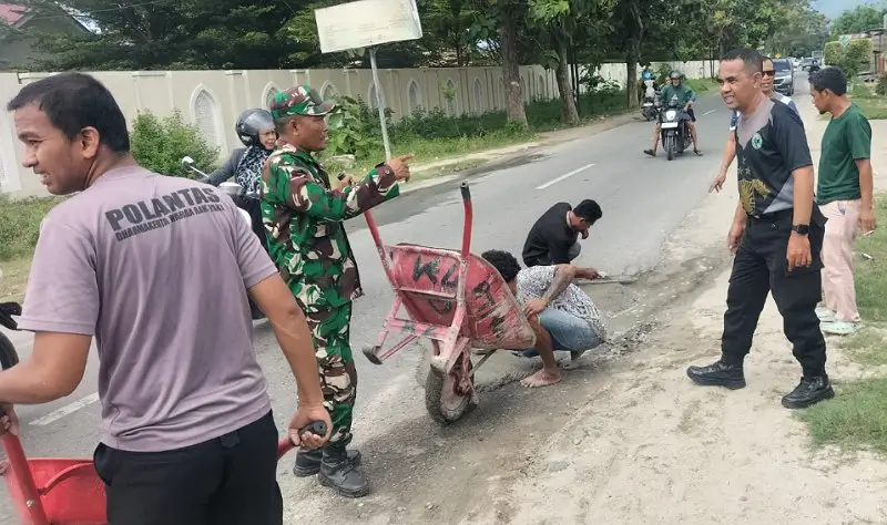 TNI-Polri dan Masyarakat Bersinergi Tambal Jalan Berlubang di Sigi Polisi, TNI dan warga bersama-sama menambal jalan untuk mencegah kecelakaan lalulintas di Sigi, Sabtu (14/6/2025). (Foto: Humas Polres Sigi)
