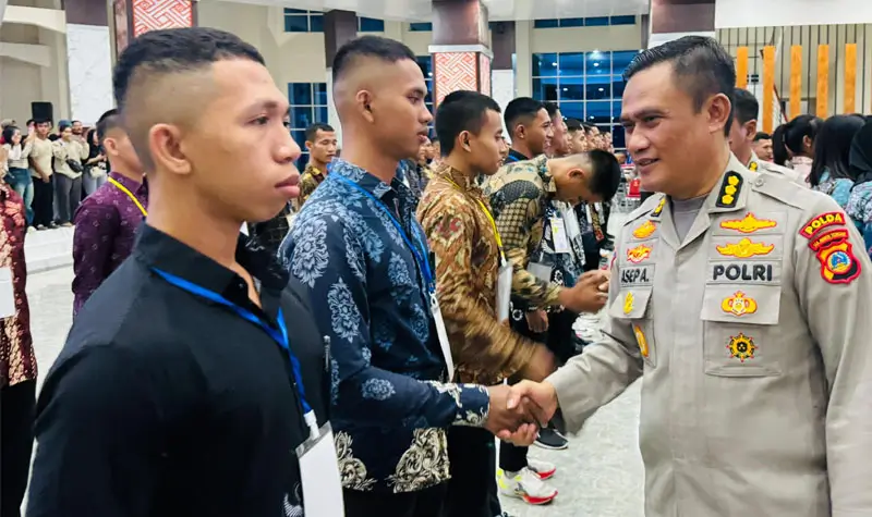 Irwasda Polda Sulteng Kombes Pol. Asep Adhiatna menyalami salah seorang peserta yang dinyatakan lulus dalam seleksi calon anggota Polri di Auditorium Untad, Rabu (2/7/2025). (Foto: Humas Polda Sutleng)