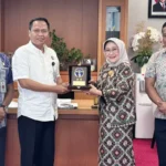 Kakanwil Kemenkum Sulteng, Rakhmat Renaldy bertukar cinderamata dengan Direktur Utama Bank Sulteng, Ramiyatie di kantor pusat Bank Sulteng, Jumat (4/7/2025). (Foto: Kemenkum Sulteng)
