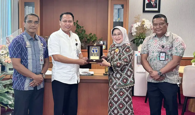 Kakanwil Kemenkum Sulteng, Rakhmat Renaldy bertukar cinderamata dengan Direktur Utama Bank Sulteng, Ramiyatie di kantor pusat Bank Sulteng, Jumat (4/7/2025). (Foto: Kemenkum Sulteng)