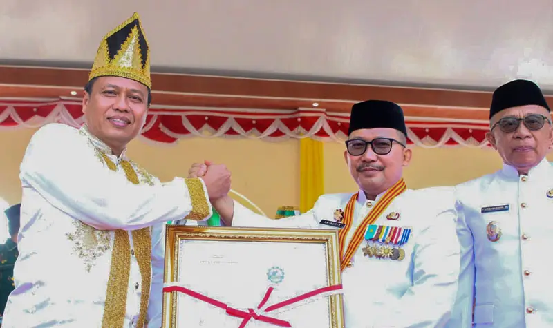 Kakanwil Kemenkum Sulteng, Rakhmat Renaldy meneyrahkan sertifikat kepada Bupati Banggai, Amirudin Tamoreka bersama Wakil Bupati Furqanuddin di Luwuk, Banggai, Selasa (8/7/2025). (Foto: Kemenkum Sulteng)