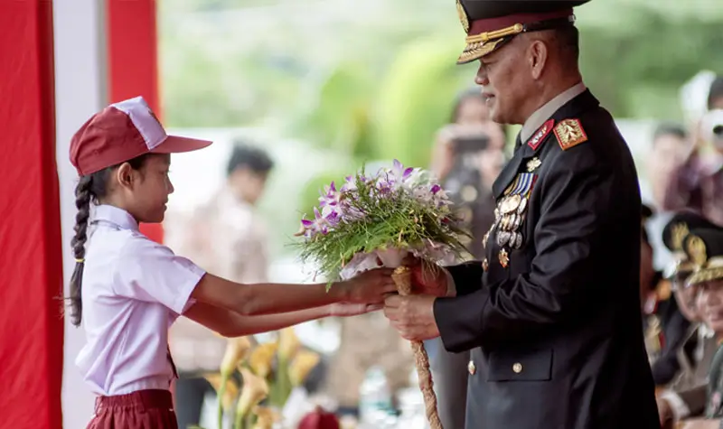 Kapolda Sulteng Irjen Pol Agus Nugroho (kiri) menerima bunga sebagai tanda ucapan selamat dari seorang pelajar SD pada peringatan Hari Bhayangkara ke-79 di halaman Kantor Gubernur Sulteng di Palu, Sulawesi Tengah, Selasa (1/7/2025). (bmzIMAGES/Basri Marzuki)