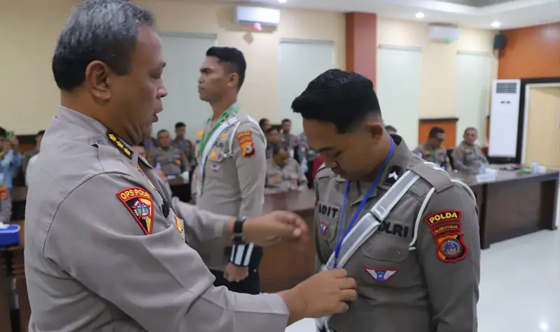 Kepala Biro Operasi (Karoops) Kombes Pol. Giuseppe Reinhard Gultom mmasangkan atribut kepada petugas dalam rangka operasi Tinombala 20245. (Foto: Humas Polda Sutleng)