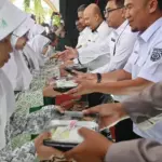 Sejumlah pejabat Kanwil Ditjen Imigrasi dan Kantor Imigrasi Kelas I TPI Palu menyerahkan secara simbolis Makanan Bergizi Gratis (MBG) kepada siswa di SD 1 Alkhairaat di Palu, Sulawesi Tengah, Rabu (13/8/2025). (©bmzIMAGES/basri marzuki)