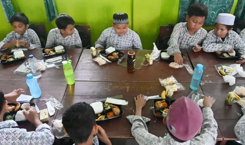 Sejumlah siswa menyantap Makanan Bergizi Gratis (MBG) pemberian Kanwil Ditjen Imigrasi dan Kantor Imigrasi Kelas I TPI Palu di SD 1 Alkhairaat di Palu, Sulawesi Tengah, Rabu (13/8/2025). (©bmzIMAGES/basri marzuki)