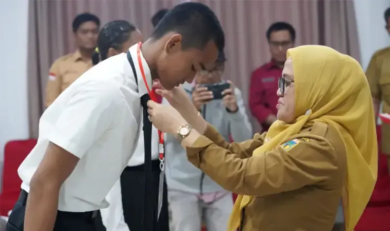 Sekkot Palu Irayanti menyematkan pita kepada peserta tanda dimulainya pemusatan altihan paskibraka 2025. (©Prokopim Setda Kota Palu/Iwan)
