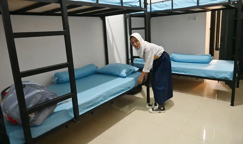 Seorang siswa merapikan tempat tidur di asrama SRT 20 Palu, Jumat (15/8/2025). (©bmzIMAGES/basri marzuki)