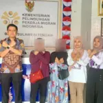 Solidaritsa Perempuan Palu mengapit pekerja migran asal Sigi yang berhasil dipulangkan. (©Solidaritas Perempuan Palu)