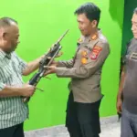 Anggota DPRD Sulteng, Baharuddin Sapi’i (kiri) menyerahkan senpi rakitan yang ditemukan warga di Poso, Rabu (13/8/2025). (©Humas Ops Madago raya)
