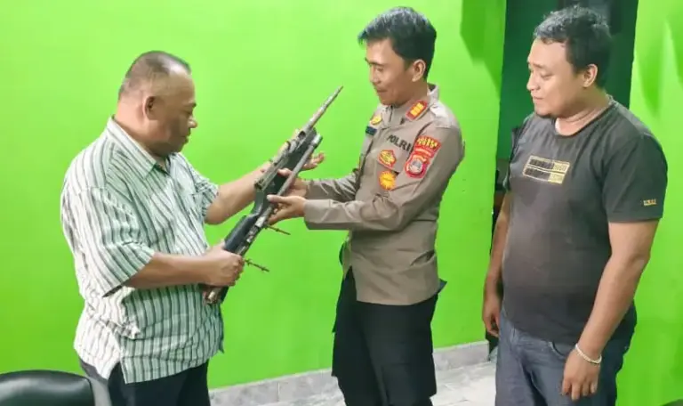 Anggota DPRD Sulteng, Baharuddin Sapi’i (kiri) menyerahkan senpi rakitan yang ditemukan warga di Poso, Rabu (13/8/2025). (©Humas Ops Madago raya)