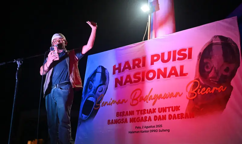 Seniman dan budayawan Arifin Sunusi mendeklamasikan puisinya dalam perayaan Hari Pusi Nasional di depan Kantor DPRD Sulteng, Sabtu (2/8/2025) malam. (©bmzIMAGES/basri Marzuki)