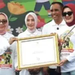 Menteri Pemberdayaan Perempuan dan Perlindungan Anak (PPPA) RI, Arifatul Choiri Fauzi menyerahkan sertifika Kota Layak Anak kepada Kepala Dinas PPPA Kota Palu, Yudhi Riyani Firman di banggai, Senin (25/08/2025). (©Diskominfosantik Palu)