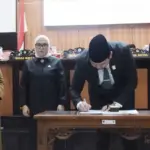 Ketua DPRD Kota, Rico A. Djanggola (tengah) bersama Sekda Kota Palu, Irmayanti (kiri) meneken berita acara persetujuan Renperda PJUT di gedung DPRD KOta Palu, Senin (25/8/2025). (©Prokopim Setda Kota Palu/Imron)