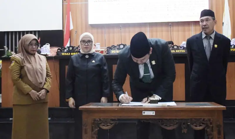 Ketua DPRD Kota, Rico A. Djanggola (tengah) bersama Sekda Kota Palu, Irmayanti (kiri) meneken berita acara persetujuan Renperda PJUT di gedung DPRD KOta Palu, Senin (25/8/2025). (©Prokopim Setda Kota Palu/Imron)