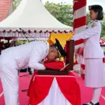 Wali Kota Palu Hadianto Rasyid mencium bendera merah putih sebelum diserahkan ke Paskibraka untuk dikibarkan di halaman Kantor Wali Kota Palu, Minggu (17/8/2025). (©Prokopim Steda Kota Palu)