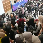 Sejumlah pencari kerja antre memasuki arena job fair di Auditorium Untad, Senin (4/8/2025). (©bmzIMAGES/basri amrzuki)