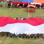 Bendera raksasa berukuran 30x20 meter dibentangkan tepat di momentum peringatan HUT ke-80 RI di Desa Tamanjeka, Poso, Minggu (17/8/2025). (©Humas Polda Suleng)