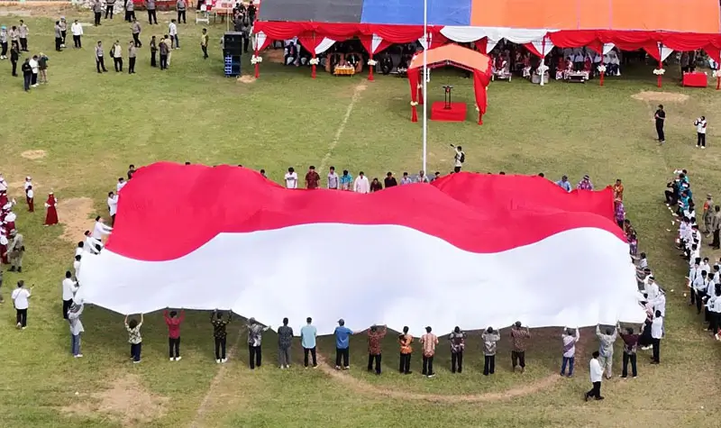 Bendera raksasa berukuran 30x20 meter dibentangkan tepat di momentum peringatan HUT ke-80 RI di Desa Tamanjeka, Poso, Minggu (17/8/2025). (©Humas Polda Suleng)