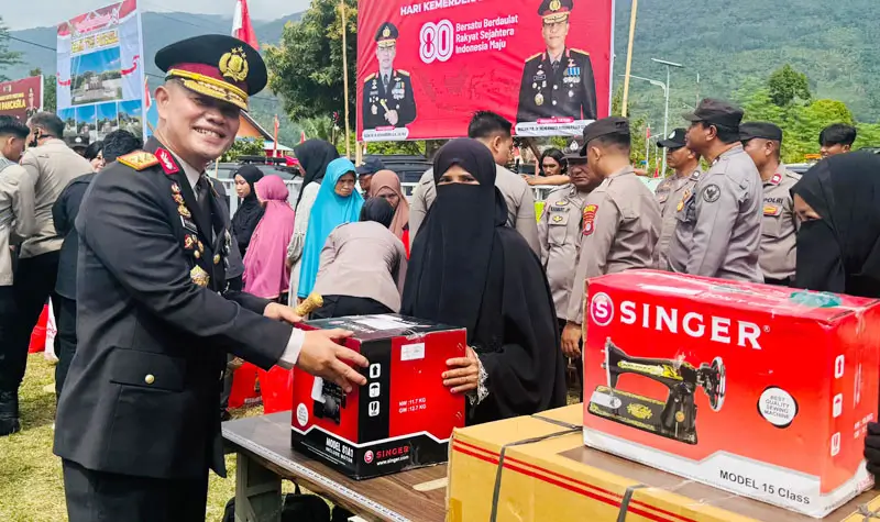 Kapolda Sulteng Irjen Pol Agus Nugroho menyerahkan bantuan sosial mesin jahit usaia upacara peringatan HUT ke-80 RI di Desa Tamanjeka, Poso, Minggu (17/8/2025). (©Humas Polda Sulteng)