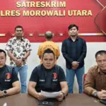 Tersangka M (tengah belakang) setelah ditangkap jajaran Polres Morut karena dugaan penggelapan dana ganti rugi tanah. (© Humas Polres Morut)