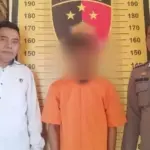 Tersangka MFA (30) diapit petugas setelah tertangkap diduba membobol rumah di Kelapa Mas Permai Kalukubula, Sigi, Jumat (8/8/2025). (©Humas Polres Sigi)