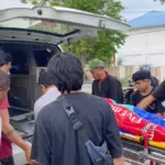Warga mengevakuasi jenazah tukang parkir yang ditemukanmeninggal di depan sebuah kafe di Jalan Jabal Nur Palu, Kamis 38/8/2025). (©Humas Polresta Palu)