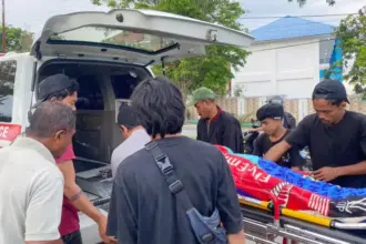Warga mengevakuasi jenazah tukang parkir yang ditemukanmeninggal di depan sebuah kafe di Jalan Jabal Nur Palu, Kamis 38/8/2025). (©Humas Polresta Palu)
