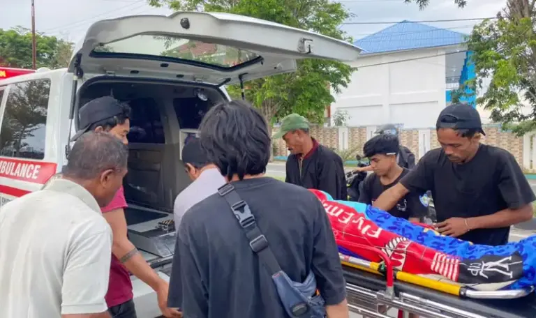 Warga mengevakuasi jenazah tukang parkir yang ditemukanmeninggal di depan sebuah kafe di Jalan Jabal Nur Palu, Kamis 38/8/2025). (©Humas Polresta Palu)