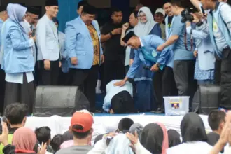 Salah seorang guru mengaji melakukan sujud syukur saat dinyatakan mendapatkan hadiah umroh pada puncak Milad BKPRMI di Palu, Minggu (14/9/2025). (©BKPRMI/Imron)