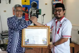 Direktur Jenderal Kekayaan Intelektual Kemenkum, Razilu menyerahkan sertfikat KBKI kepada Ketua DPD PAPPRI, Umariadi Tangkilisan di Palu, Jumat (27/9/2025). (©Kemenkum Sulteng)