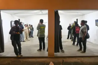 Sejumlah pengunjung memperhatikan sejumlah video art lintas negara yang dipamerkan di Palu, Sulawesi Tengah, Sabtu (13/9/2025). (©bmzIMAGES/basri marzuki)